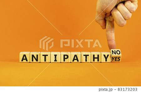 Antipathy yes or no symbol. Psychologist turns a wooden cube and change words 'antipathy no' to 'antipathy yes'. Beautiful orange background. Business and antipathy yes or no concept, copy space. 83173203