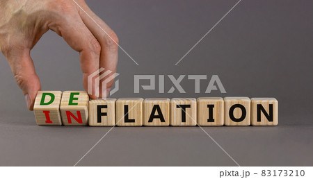 Inflation or deflation symbol. Businessman turns cubes and changes the word inflation to deflation. Beautiful grey background, copy space. Business, inflation or deflation concept. 83173210