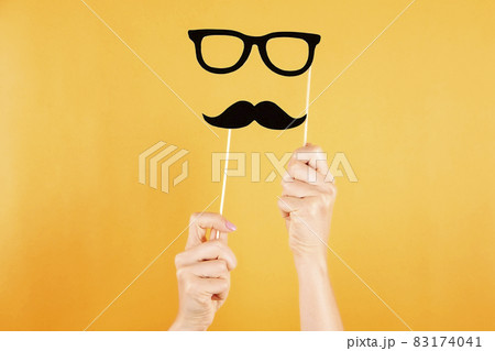 Paper party attributes in form of mustache on wooden stick. Carnival accessory concept. 83174041