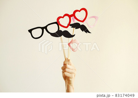 Paper party attributes in form of moustache on wooden stick. Carnival accessory concept. Paper party attributes in form of moustache on wooden stick. Carnival accessory concept. 83174049
