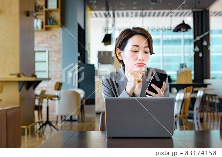 カフェでスマホを操作するビジネスウーマン 83174158