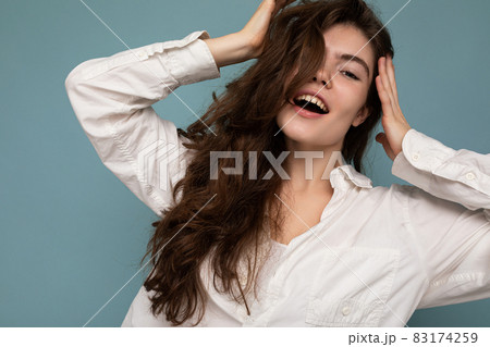 Photo of young beautiful happy smiling curly brunette woman wearing white shirt. Sexy carefree 83174259