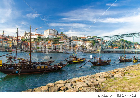 Portugal, city landscape Porto, wooden boats with wine port barrels close up on Douro river 83174712
