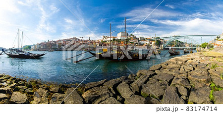 Portugal, city landscape Porto, wooden boats with wine port barrels close up on Douro river 83174714