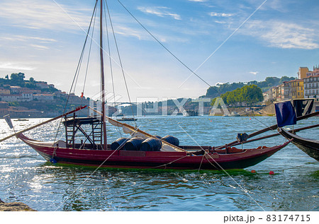 Portugal, city landscape Porto, wooden boats with wine port barrels close up on Douro river 83174715