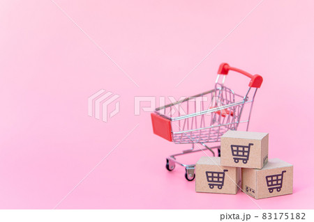 Shopping concept : Cartons or Paper boxes in red shopping cart on pink background. online shopping consumers can shop from home and delivery service. with copy space 83175182