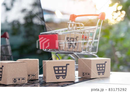 Shopping online - Parcel or Paper cartons with a shopping cart logo in a trolley on a laptop keyboard. Shopping service on The online web. offers home delivery. 83175292