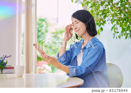 老眼でスマホが見えにくいミドル女性 83176044