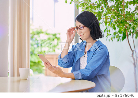 老眼でスマホが見えにくいミドル女性 83176046