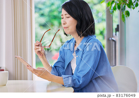 老眼でスマホが見えにくいミドル女性 83176049