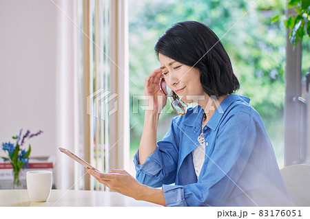 老眼でスマホが見えにくいミドル女性 83176051
