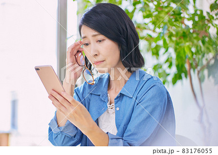 老眼でスマホが見えにくいミドル女性 83176055
