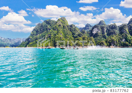 Wooden Thai traditional long-tail boat on a lake with mountains at Ratchaprapha Dam, Thailand 83177762