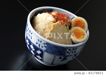 煮玉子と万能葱と糸切り唐辛子が乗っている鶏チャーシュー丼を黒背景で撮影 煮玉子と万能葱と糸切り唐辛子が乗っている鶏チャーシュー丼を黒背景で撮影 83178651
