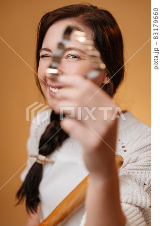 Woman looks through metal shape in the form Christmas tree for baking. Woman looks through metal shape in the form Christmas tree for baking. 83179660