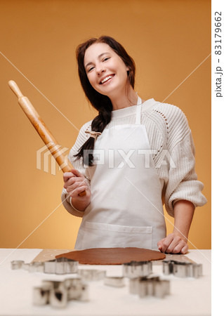Woman joyfully holds a roller bake Christmas cookies. Woman joyfully holds a roller bake Christmas cookies. 83179662