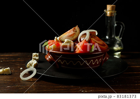 Homemade salad of tomatoes, feta cheese and onions, with olive oil. In a ceramic bowl, low key, horizontal. Homemade salad of tomatoes, feta cheese and onions, with olive oil. In a ceramic bowl, low key, horizontal. 83181373