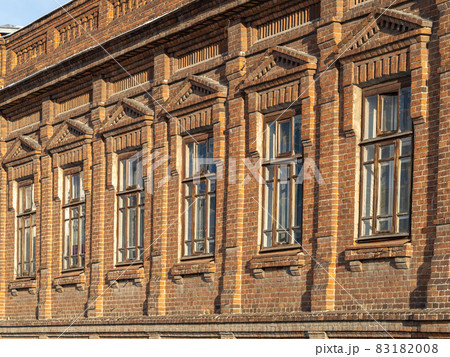 Brick wall of an old 19th century building with large windows. Wall of an old red brick building with six windows 83182008