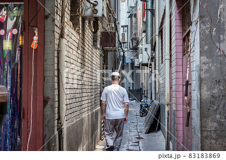 Hui Muslim ethnic minority man walking down a hutong street in Xian, China 83183869