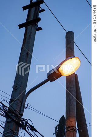 Yellow lantern on a concrete pole against the background of the dark sky. 83184439