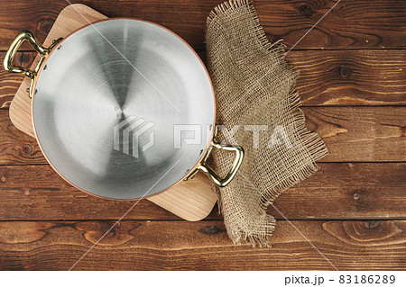 Clean shiny copper kitchenware on wooden board Clean shiny copper kitchenware on wooden board 83186289