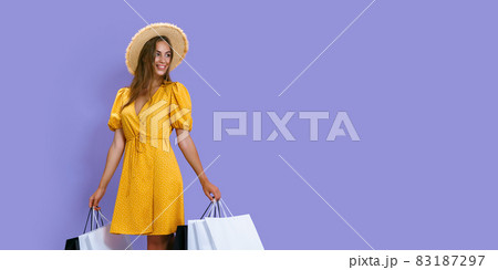 Fashion happy girl holds packages after shopping on purple background. discount, black Friday, sales 83187297