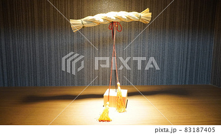 スポットライトに照らされる藁で作られた日本の伝統的なしめ縄細工 83187405