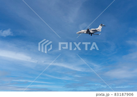 private jet while landing on a blue sky private jet while landing on a blue sky 83187906