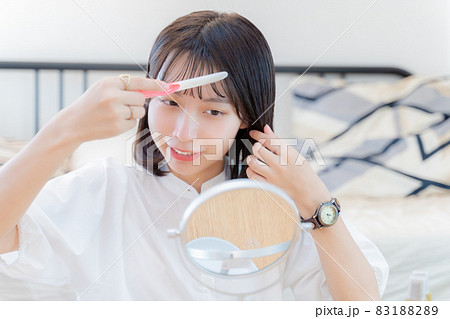 前髪を直す笑顔の女性 83188289