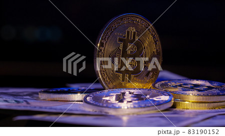 Bitcoin BTC coin and Ethereum ETH coins rotating on bills cash of 100 dollars, virtual money mining 83190152