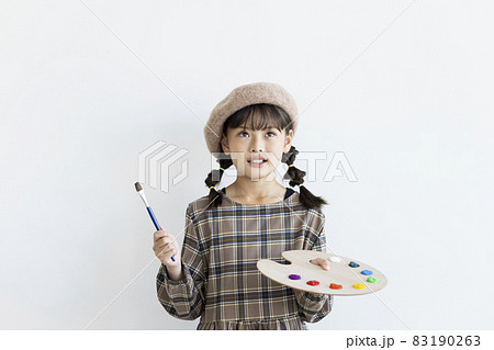 絵の具のパレットと筆を持った女の子 画家の写真素材