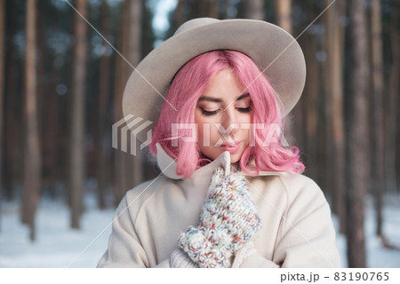 Winter woman looking down outdoors in snow on cold winter day Winter woman looking down outdoors in snow on cold winter day 83190765