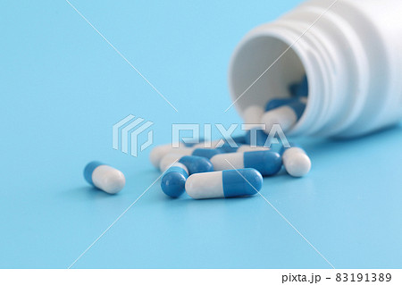 pills capsules with bottle isolated on blue background 83191389