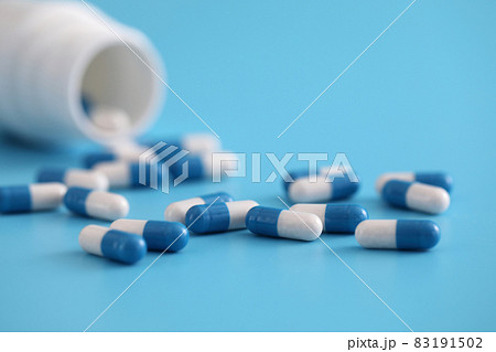 pills capsules with bottle isolated on blue background 83191502