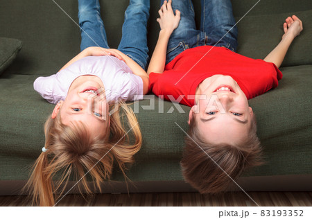 Happy siblings on a sofa Happy siblings on a sofa 83193352