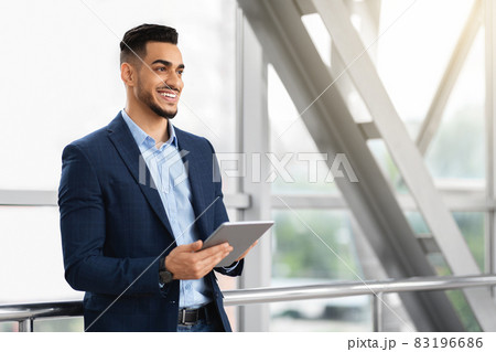 Portrait Of Handsome Middle Eastern Businessman Using Digital Tablet At Airport 83196686