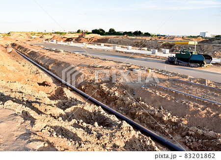 Asphalting the road and laying the sewer pipe at the construction site. Asphalt paver machine  83201862