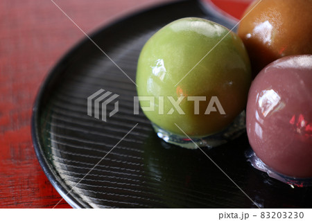 漆塗りの板背景のお皿にのせた餡子玉 83203230