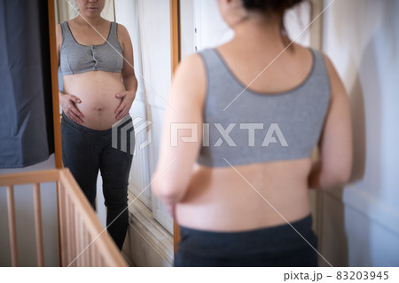 pregnant asian women checking her body with mirror pregnant asian women checking her body with mirror 83203945
