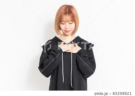考え事をしながら胸に手を当てる若い女性 考え事をしながら胸に手を当てる若い女性 83208921