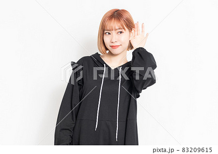 聞き耳を立てて噂話を聞く若い女性 聞き耳を立てて噂話を聞く若い女性 83209615