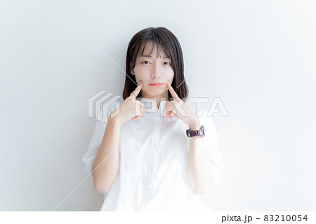 真顔で指を頬に当てる女性 83210054