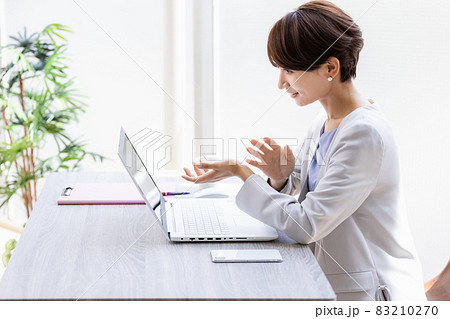 ビデオ通話をしている笑顔のビジネスウーマン ビデオ通話をしている笑顔のビジネスウーマン 83210270