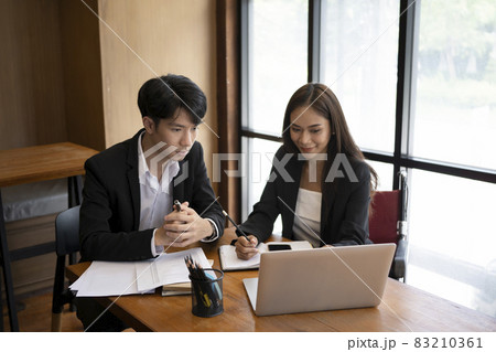 Smiling businesswoman in wheelchair working  in office with colleague. 83210361
