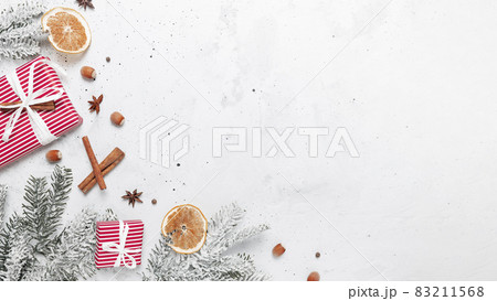 Christmas flat lay top view on white gray concrete background table with glass cup or mug of Mulled Wine, present red gift boxes, decorations, cinnamon sticks, hazelnut, dried or sublimated orange Christmas flat lay top view on white gray concrete background table with glass cup or mug of Mulled Wine, present red gift boxes, decorations, cinnamon sticks, hazelnut, dried or sublimated orange 83211568