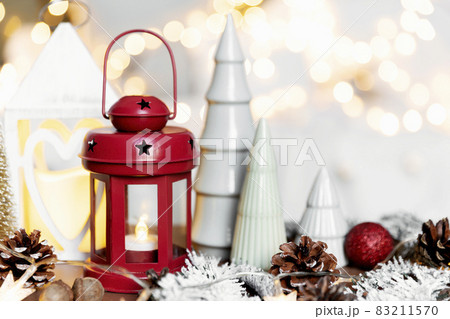 Christmas or New Year composition with various home decorations, different symbolic toys composed and ordered at coffee table with blurred Christmas lights background at sofa white cover. Family time 83211570