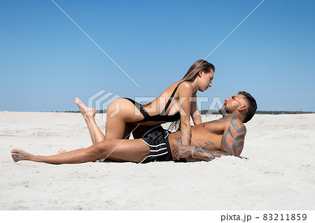 Hot couple lying on sandy seashore Hot couple lying on sandy seashore 83211859
