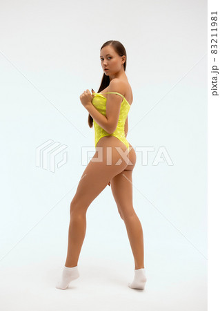 Fit woman in bodysuit standing in studio 83211981
