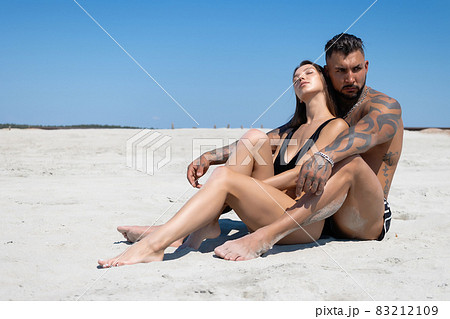 Hot couple lying on sandy seashore 83212109