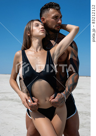 Sexy couple embracing on beach in summer 83212112